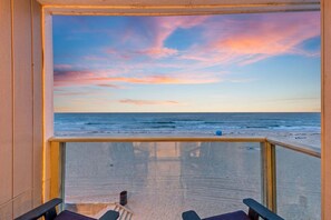 A beach view from a wooden deck with a glass railing, overlooking the ocean and a clear sky. - Oceanfront Mission Beach Penthouse w/ Private Deck, Panoramic Pacific Views & Garage Parking (San Diego)