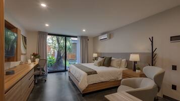 Ein modernes Hotelzimmer mit Bett, Schreibtisch, Stuhl und Fernseher.