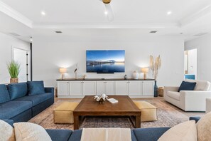 Ein modernes Wohnzimmer mit einer Couch, einem Couchtisch und einem Fernseher.