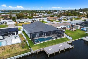 Ein modernes Haus mit Pool, Steg und Blick auf das Wasser.