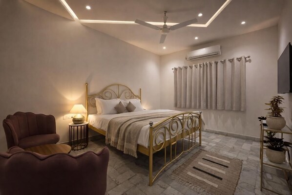 A bedroom with a bed, a chair, a lamp, a ceiling fan, and an air conditioning unit.