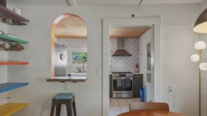 Cozinha com fogão, forno e vista para a sala de jantar.