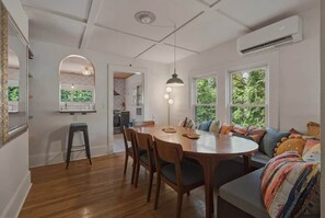 A dining area with a round table, chairs, and a bench. There is a window with a view of greenery outside. - 5BR home, walkable, pet friendly w/sauna & theatre (Black Mountain)