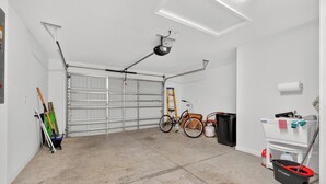 Eine Garage mit Fahrrad, einer Leiter und Putzmitteln.