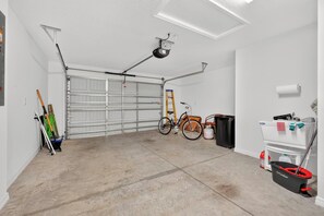 Eine Garage mit Fahrrad, einer Leiter und Putzmitteln.