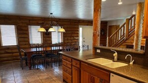 A kitchen with wooden cabinets, a granite countertop, and a built-in dishwasher. - Log Cabin in Kirkland, Arizona (Kirkland)