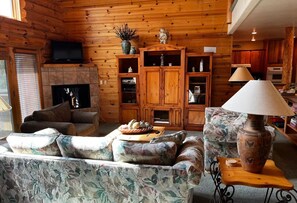 Ein gemütliches Wohnzimmer mit Kamin, Holzschnitzschränken und einem Fernseher.