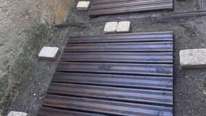 Un étroit sentier extérieur, agrémenté de marches en bois et de blocs de pierre.