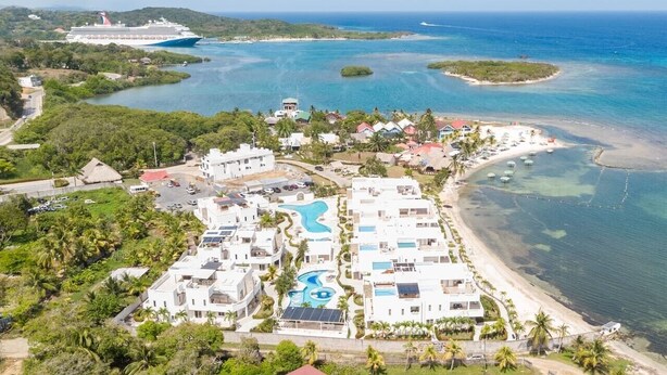 Un complexe hôtelier comprenant plusieurs bâtiments, une piscine et une plage.