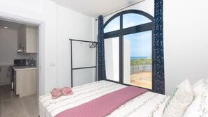 Une chambre avec un lit, une vue sur l’extérieur, une kitchenette et une salle de bain.