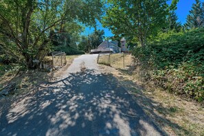 Un camino de grava que conduce a una zona residencial cerrada, con casas al fondo.