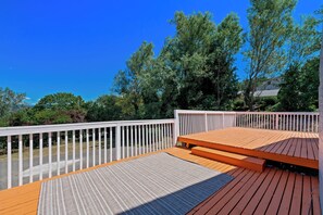 A wooden deck with a white railing, a bench, and a view of trees and a clear sky. - Private 4BR • Free Parking • Near Airport & Seattle (Tukwila)