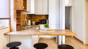 A compact kitchen with a wooden countertop, a sink, a microwave, and cabinets. - Stunning apartment in Stinjan (Stinjan)