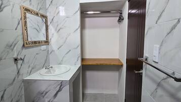 Een badkamer met toilet, wastafel, spiegel en douche.