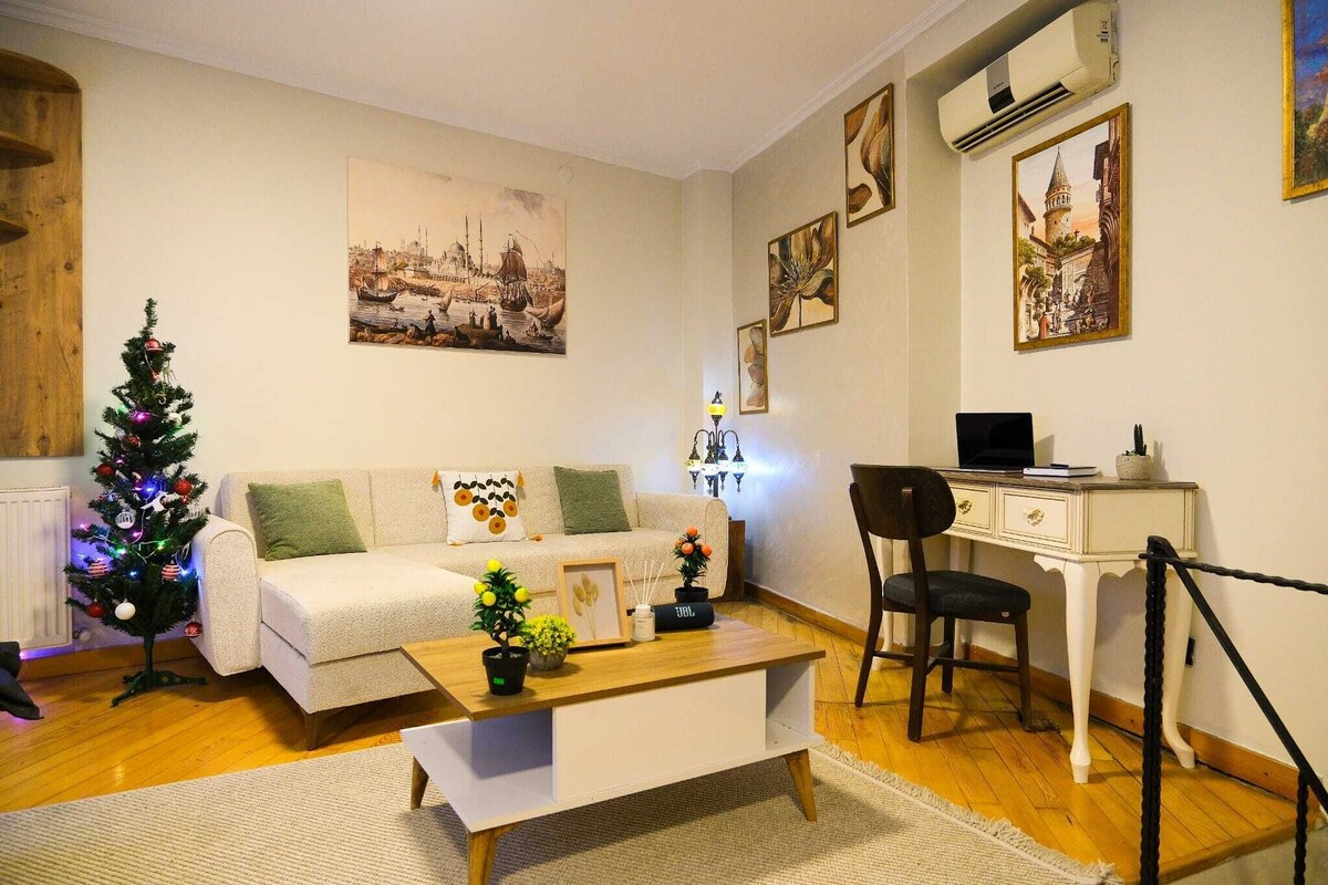 A living room with a sofa, coffee table, and a small Christmas tree.