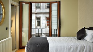 Un dormitorio con cama, ventana y puerta.