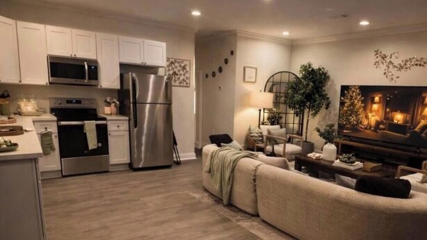 A modern kitchen with stainless steel appliances and a dining area with a sofa and a TV. - Modern2Bed2Bath Oasis 3 mins to LSUlFreeParking (Baton Rouge)