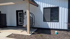 A modern building with a white exterior, a black door, and a large window. - Dune Haus + Indiana National Dunes Park (Portage)