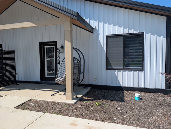 A modern building with a white exterior, a black door, and a large window. - Dune Haus + Indiana National Dunes Park (Portage)