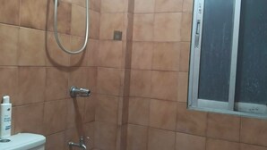 A bathroom with a shower, toilet, and a window. - 2-BR w/ Full Kitchen & AC near Farmer’s Market, Araneta Coliseum & Greenhills (Quezon City)