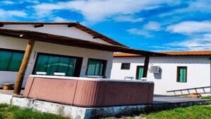 A modern building with a flat roof, large windows, and a visible air conditioning unit. - Green Village  (Barreirinhas)