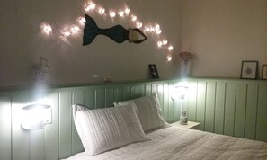 A bed with white bedding, a green headboard, and wall-mounted lights. - Floripa, the magic island - the life you always dreamed of,
now in your hands (Lagoa da Conceição Florianópolis)
