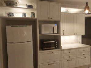 A kitchen with a refrigerator, microwave, and toaster on white cabinets. - Floripa, the magic island - the life you always dreamed of,
now in your hands (Lagoa da Conceição Florianópolis)