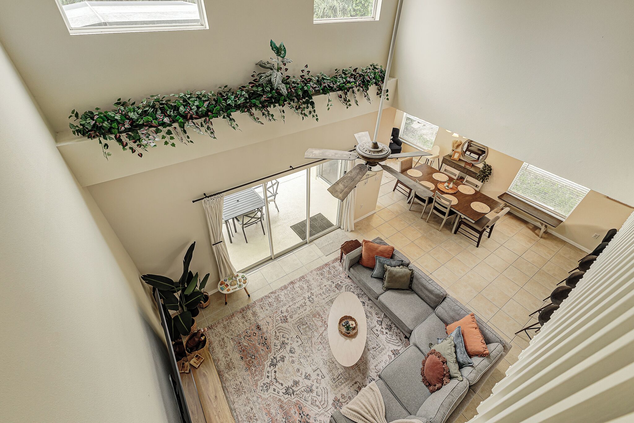 A spacious living area with a high ceiling, a dining table, and a sofa.