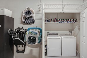 Ein Waschraum mit Waschmaschine, Trockner und diversen Waschmitteln.