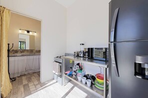 Una cocina compacta equipada con refrigerador, estufa y cafetera.
