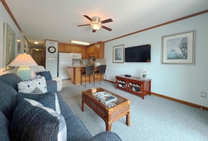 A living room with a sofa, coffee table, and a television. - Whispering Sands II 204 - Second Row Complex (Oceanview unit) in Garden City Beach (Garden City Beach)