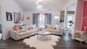 A modern living room with a sofa, coffee table, and a fluffy rug.