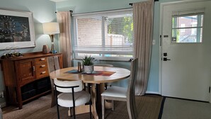 A dining area with a round table, two chairs, a potted plant, and a window with blinds. - Fiesta !-Fantastic 1-bedroom apartment with AC in charming Covington (Covington)
