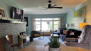 A living room with a fireplace, a sofa, a dining table, and a TV. - Fiesta !-Fantastic 1-bedroom apartment with AC in charming Covington (Covington)