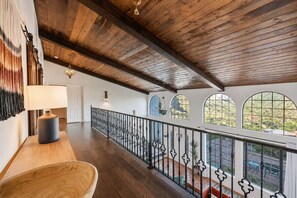 A spacious balcony with a wooden floor, a black metal railing, and a view of the outdoors. - Desert Sunsets Wellness Villa - Pool, Sauna, Spa, Pool Table, Firepit, Yoga, Steam Room & Stunning Views (Yucca Valley)
