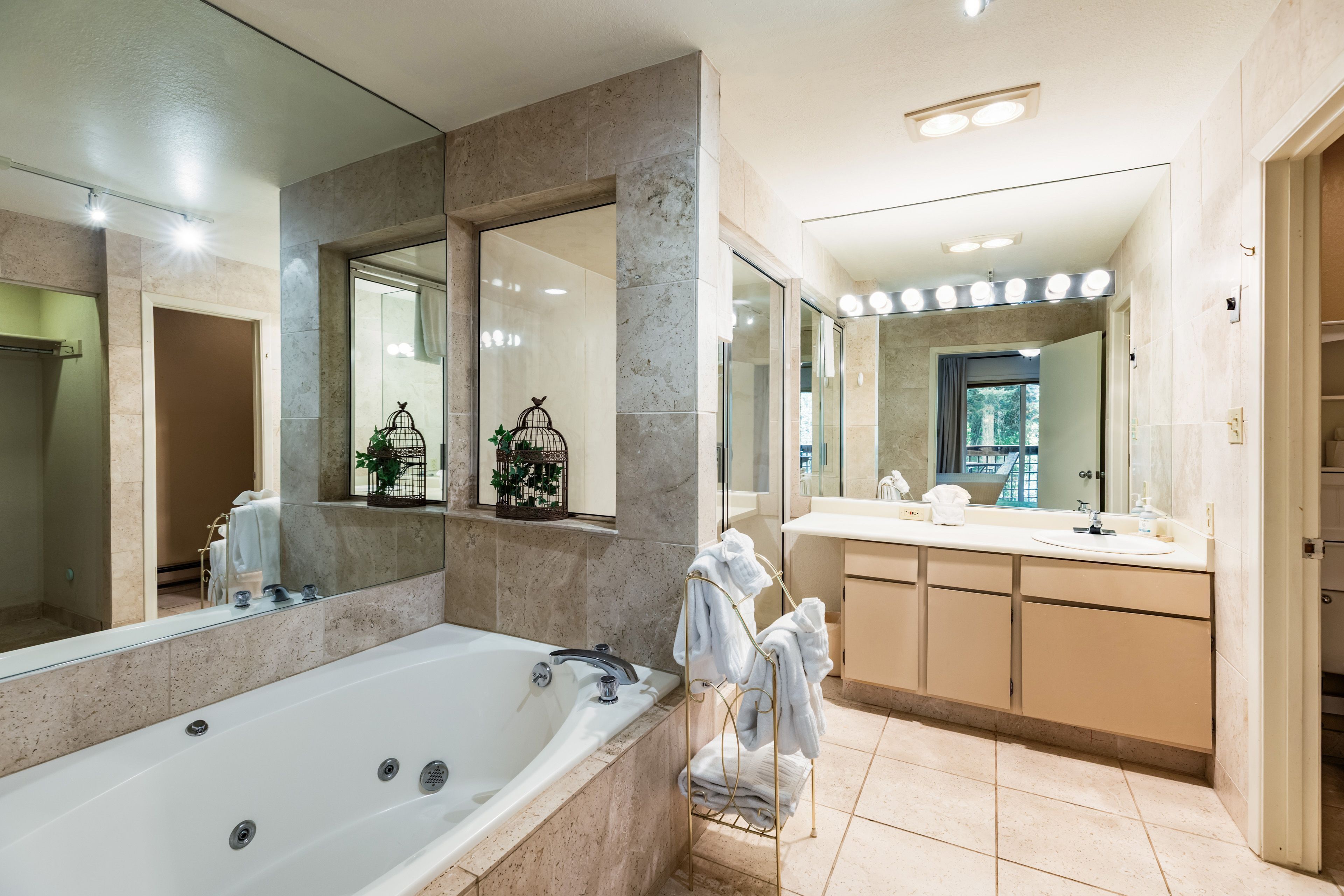 Un baño moderno con una bañera grande, un tocador con espejo y una zona de ducha.