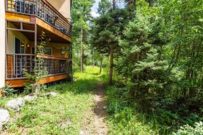Een gebouw met een houten balkon en een pad door het bos.