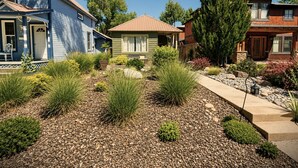 A residential area with houses, a well-maintained garden with various plants, and a clear sky. - Walk to Downtown Long Term Rental with Wifi, Grill, Yard (Durango)
