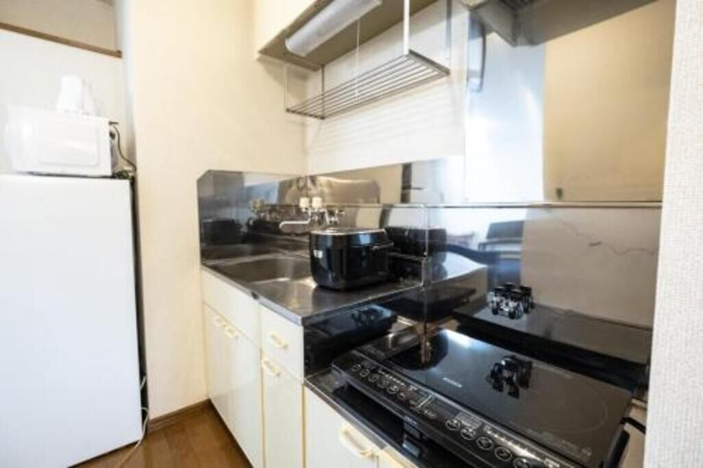 Una cocina funcional con estufa, microondas y pileta.