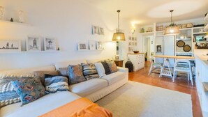 Una sala de estar acogedora con un sofá, un comedor con una mesa y sillas, y una cocina al fondo.