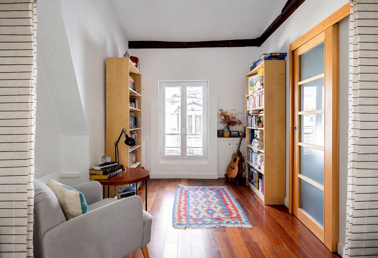 A cozy reading nook with a sofa, a small table, and a bookshelf.