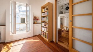 A room with a large open window, a wooden bookshelf, and a view of a laundry room. - Appartement Panorama Sacré-Cœur - Welkeys (Paris)