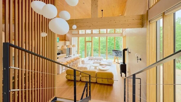 A modern interior with a staircase, wooden walls, and large windows. - Grand Tsuru B (Niseko)
