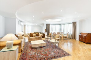 Ein geräumiges Wohnzimmer mit einer Sofagarnitur, einem Couchtisch und einem gemusterten Teppich.