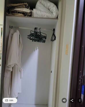 A closet with hanging clothes and a folded blanket. - ManilaBay Home Condominium Admiral Baysuites East Wing.
Close to Mall of Asia,, (1100 M.H DEL MABINI METRO MANILA)