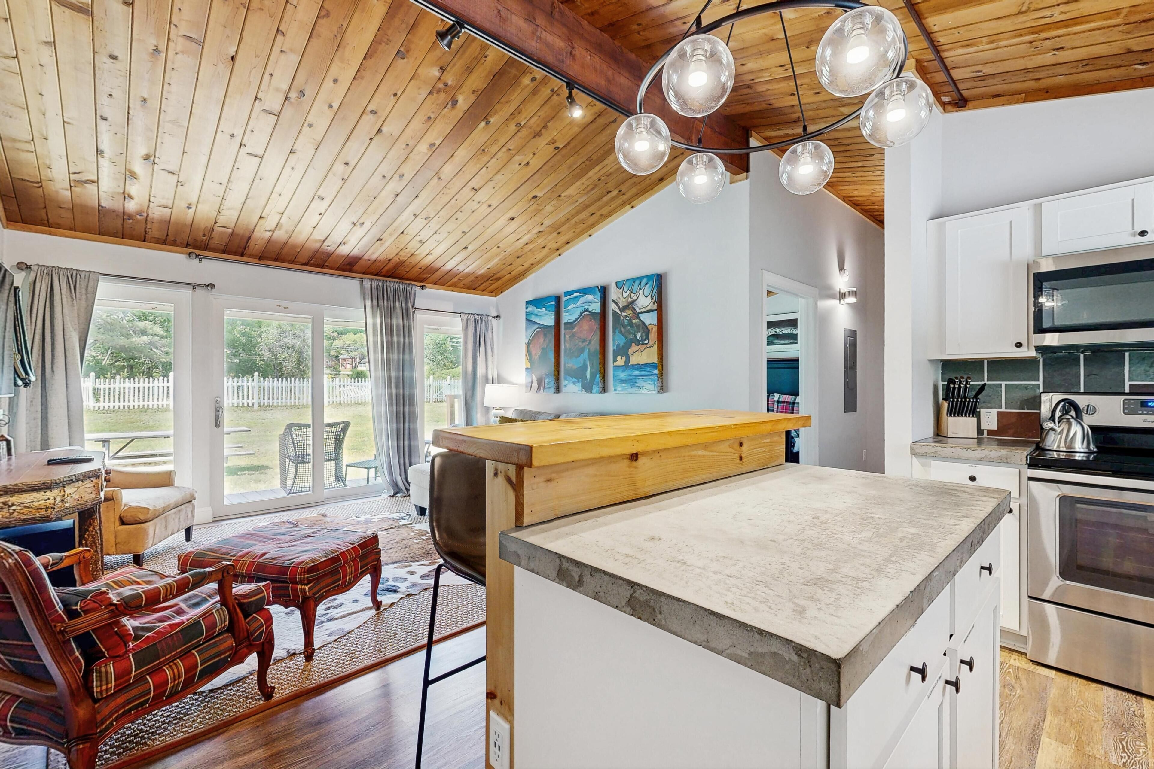 A modern kitchen with white cabinets, a wooden countertop, and a built-in oven.