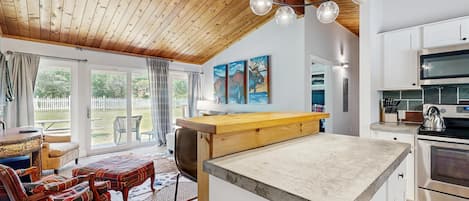 A modern kitchen with white cabinets, a wooden countertop, and a built-in oven.