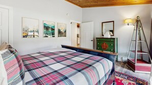 Ein Schlafzimmer mit einem Bett, einem Schminktisch, einem Spiegel und Bildern an der Wand.