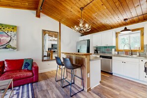 A modern kitchen with a wooden ceiling, a bar area, and a red leather sofa. - Griffin Country Lodge Chalet 5 apartment, a mile from the Toll House Lift (Stowe)