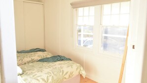 A bedroom with a bed, a window, and a door. - Mallee Drift - Exhale and Relax (James Well)